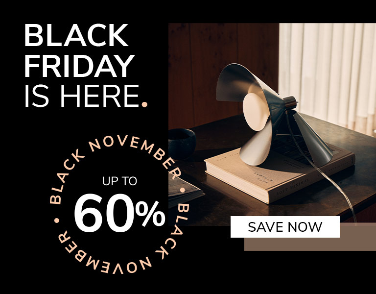 Shop now A modern table lamp with angled metal blades sits on top of a book on a dark wooden desk in soft daylight. Text reads: ‘Black Friday is here. Up to 60%. Save Now.