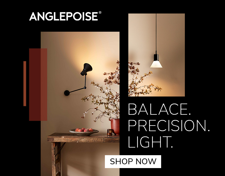 Shop now A black Anglepoise wall lamp illuminating a rustic wooden table with a bowl of fruit and a vase of branches. Another minimalist pendant light hangs on a beige wall. Text reads: ‘Anglepoise. Balance. Precision. Light.’ A button says ‘Shop Now.